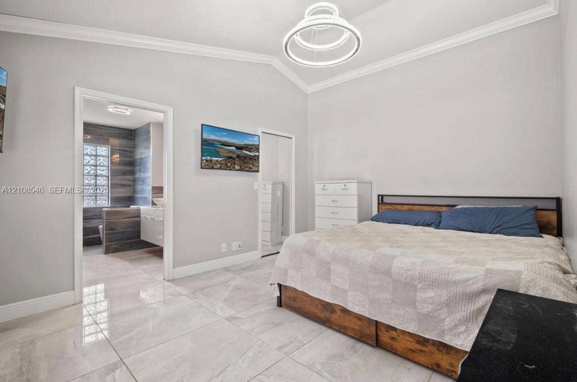 Vaulted ceilings with crown molding, polished stone-finish floor tile, and a contemporary multi-ring pendant light fixture