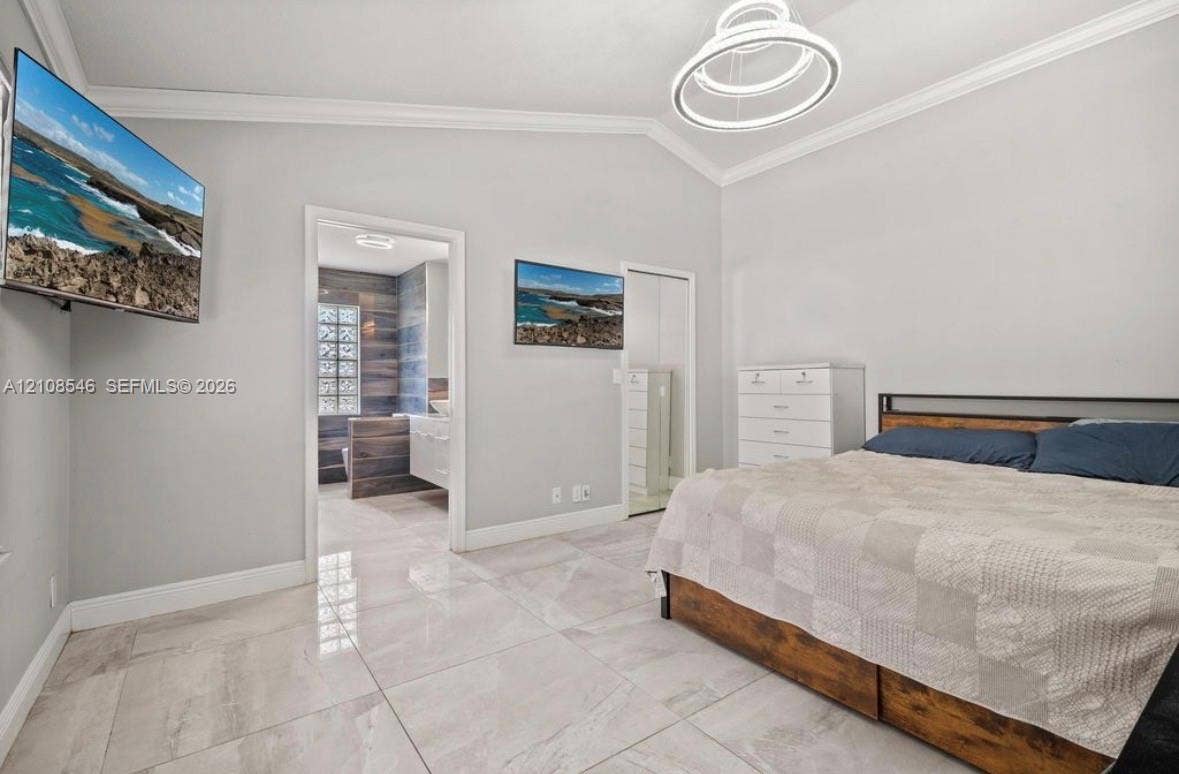 Vaulted ceilings featuring a contemporary circular LED pendant light, large-format tile flooring, and clean crown molding