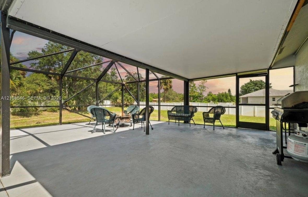Screened lanai featuring a solid roof structure, concrete flooring, and metal framing