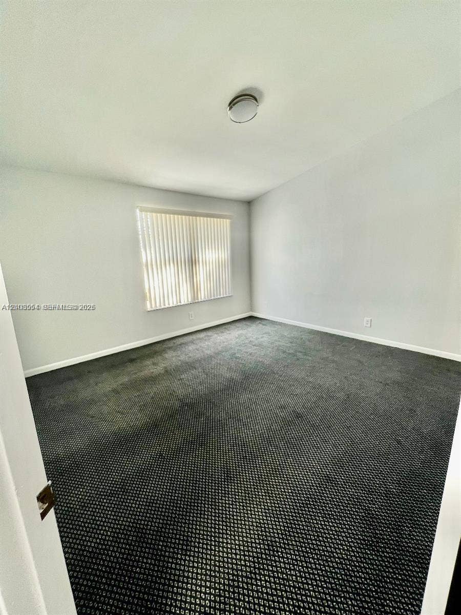 Room featuring dark wall-to-wall carpeting, neutral-toned walls, and a recessed ceiling light fixture