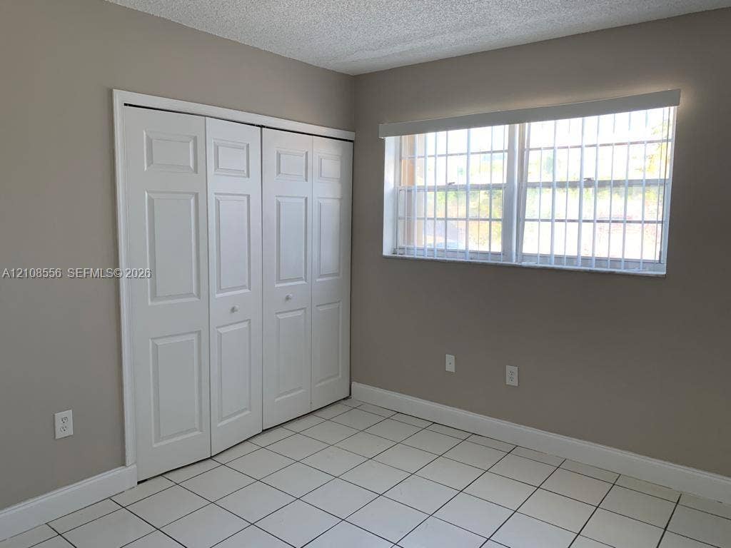 600 SW 2nd Avenue, #137, Boca Raton, FL 33432 Room featuring white tile flooring, neutral wall paint, and a white paneled closet door