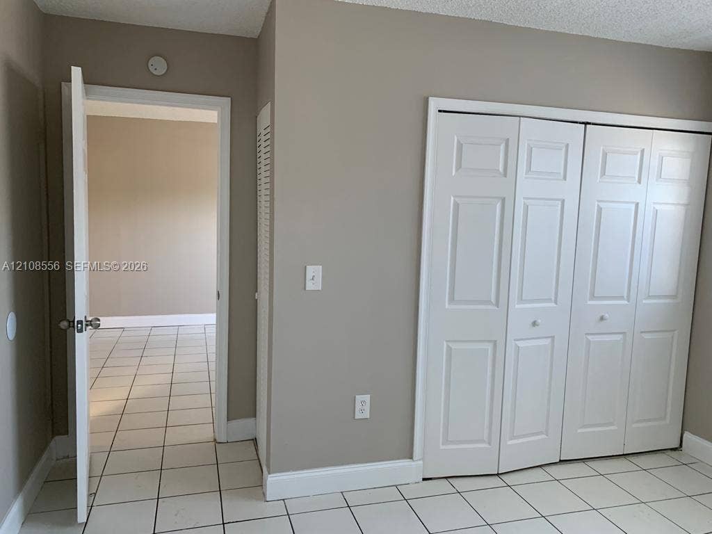 600 SW 2nd Avenue, #137, Boca Raton, FL 33432 Neutral-tone walls, white ceramic tile flooring, and a multi-panel white closet door