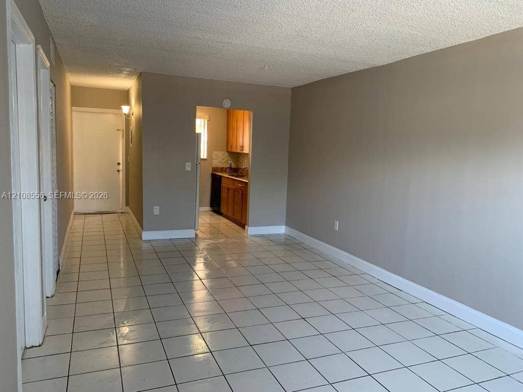 600 SW 2nd Avenue, #137, Boca Raton, FL 33432 Interior space featuring light-colored tile flooring, neutral wall tones, and built-in cabinetry within the kitchen area