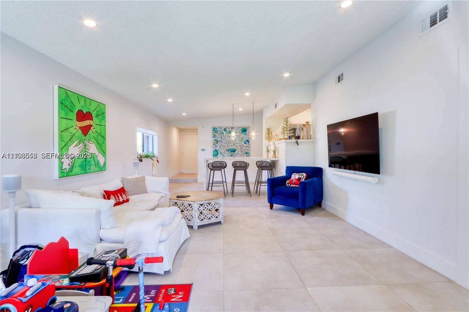 10478 SW 75th Lane, #10478, Miami, Miami, FL 33173 Open-concept interior featuring large-format tile flooring, recessed ceiling lighting, and a built-in kitchen breakfast bar