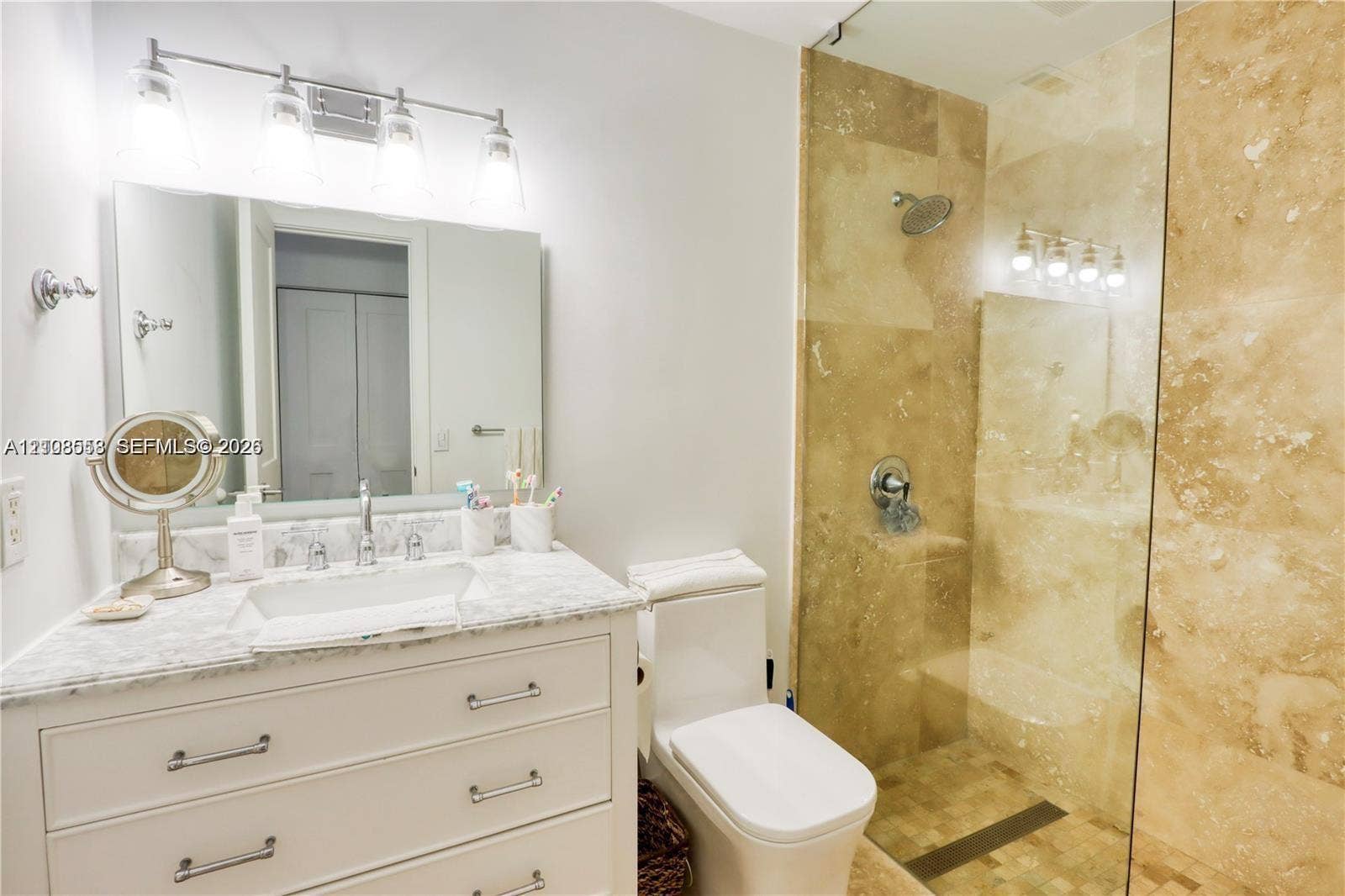 10478 SW 75th Lane, #10478, Miami, Miami, FL 33173 Bathroom featuring a vanity with stone countertop, undermount sink, four-light vanity fixture, and a glass-enclosed shower with tiled walls