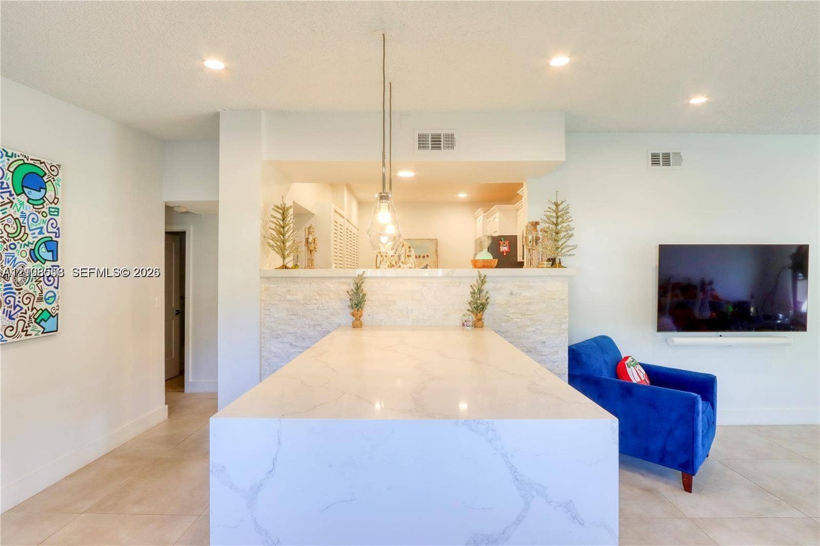 10478 SW 75th Lane, #10478, Miami, Miami, FL 33173 Kitchen island featuring a waterfall-edge countertop, stone-textured facade, and pendant lighting