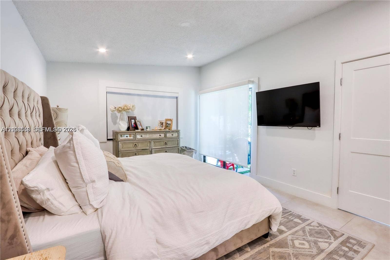 10478 SW 75th Lane, #10478, Miami, Miami, FL 33173 Neutral-toned interior featuring recessed ceiling lighting, light-colored tile flooring, and a sliding glass door with roller shade