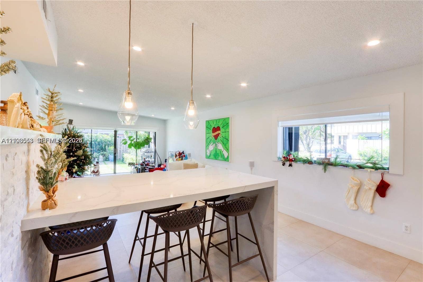 10478 SW 75th Lane, #10478, Miami, Miami, FL 33173 Waterfall island with stone-surface countertop, recessed ceiling lighting, clear glass pendant fixtures, and large-format tile flooring