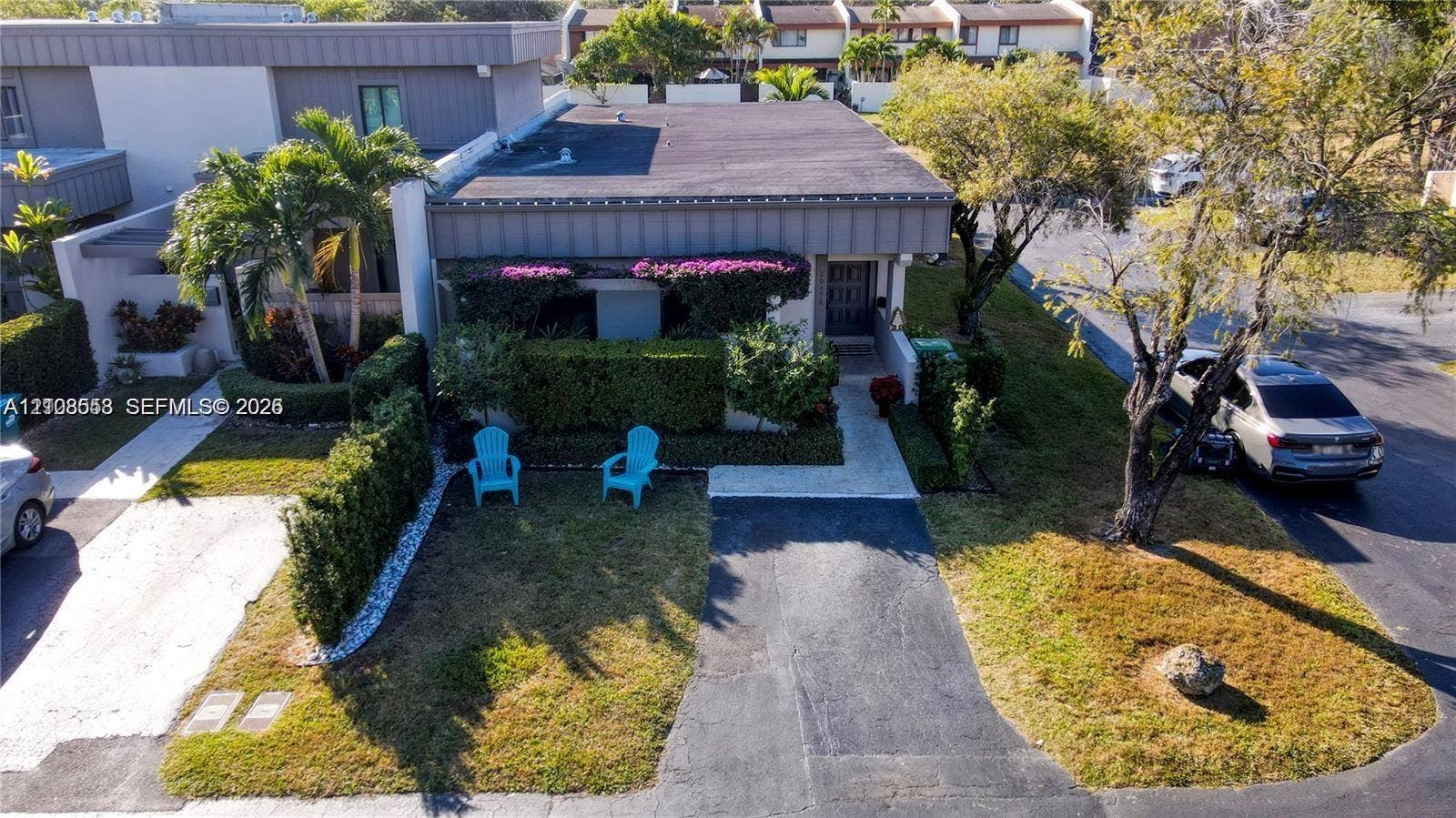 10478 SW 75th Lane, #10478, Miami, Miami, FL 33173 Exterior facade featuring a flat roofline, integrated landscaping, manicured privacy hedges, and a paved private driveway