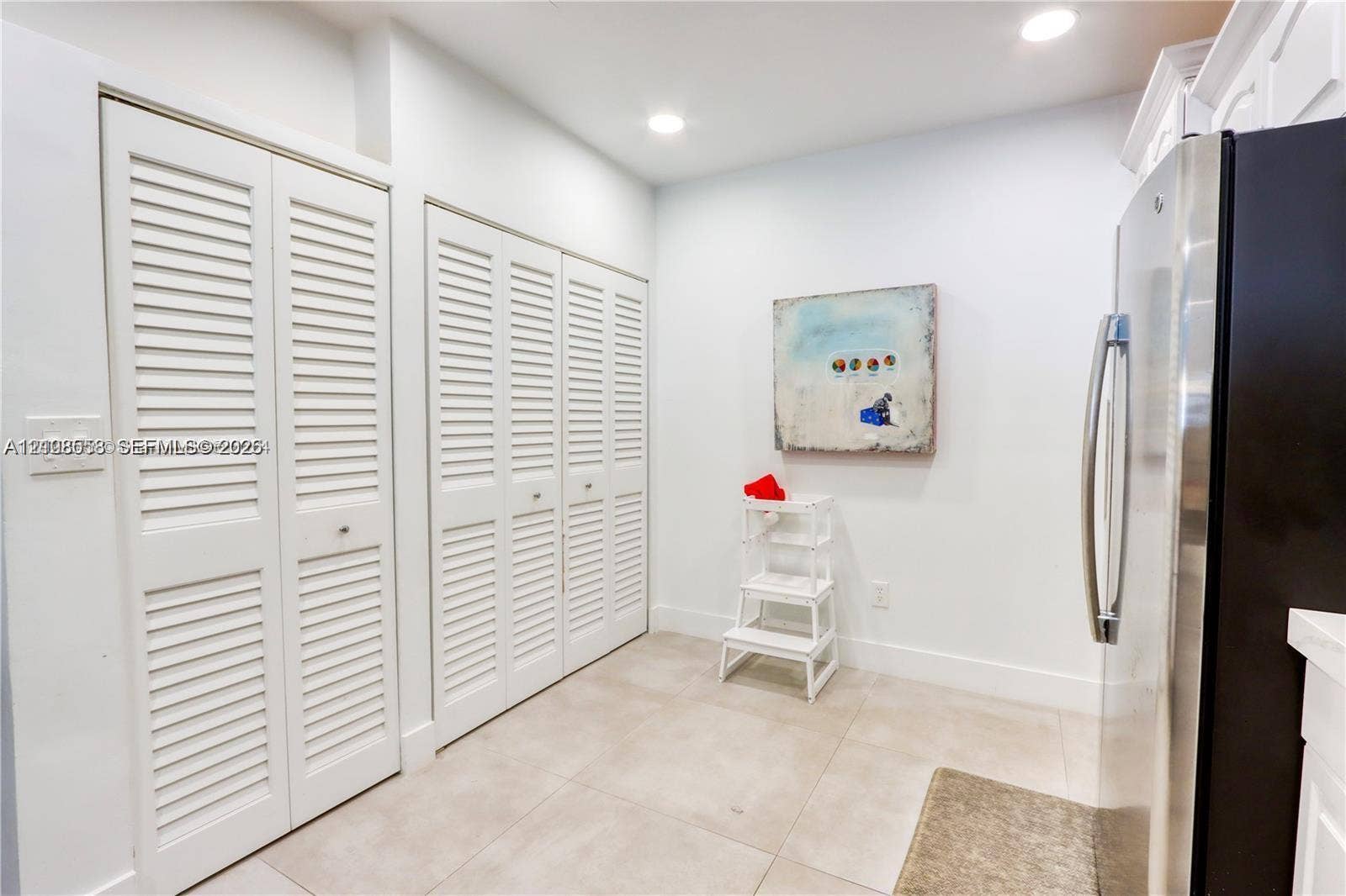 10478 SW 75th Lane, #10478, Miami, Miami, FL 33173 Large-format tile flooring paired with floor-to-ceiling white louvered closet doors and recessed lighting
