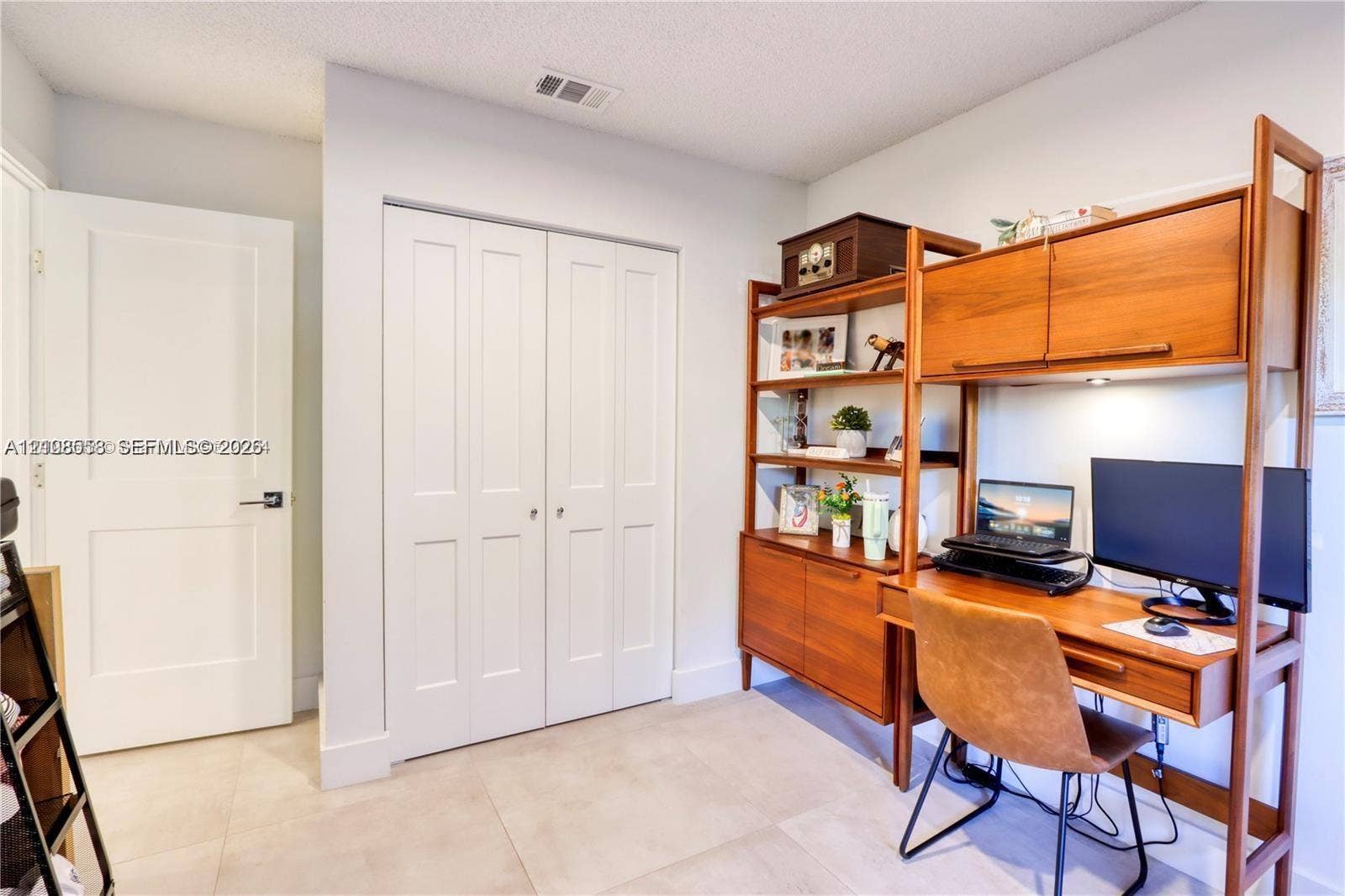 10478 SW 75th Lane, #10478, Miami, Miami, FL 33173 Neutral-toned tile flooring, white interior doors, and double-panel closet doors with hardware