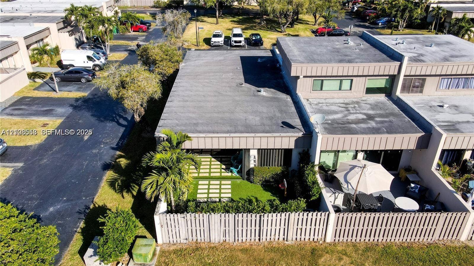 10478 SW 75th Lane, #10478, Miami, Miami, FL 33173 Multi-unit residential structure with flat roofing and a private, fenced-in patio area featuring paver-and-turf hardscaping
