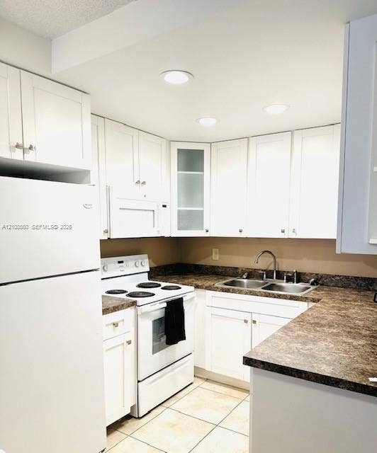 22 SE 3rd Terrace, #6, Dania, Dania Beach, FL 33004 Kitchen featuring white cabinetry with glass-panel accents, stone-patterned laminate countertops, double-basin stainless steel sink, recessed lighting, and tile flooring