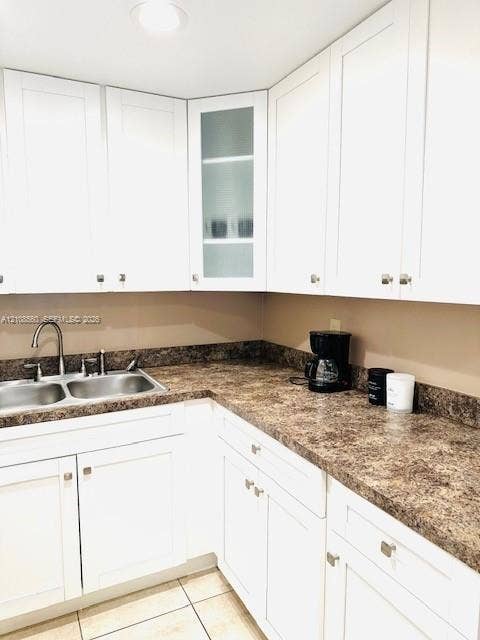 22 SE 3rd Terrace, #6, Dania, Dania Beach, FL 33004 Kitchen featuring white shaker-style cabinetry, a glass-panel display cabinet, laminate countertops, a stainless steel double-basin sink, and tile flooring