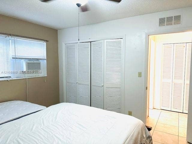 22 SE 3rd Terrace, #6, Dania, Dania Beach, FL 33004 Room featuring dual bifold louvered closet doors, window with integrated air conditioning unit, and ceramic tile flooring