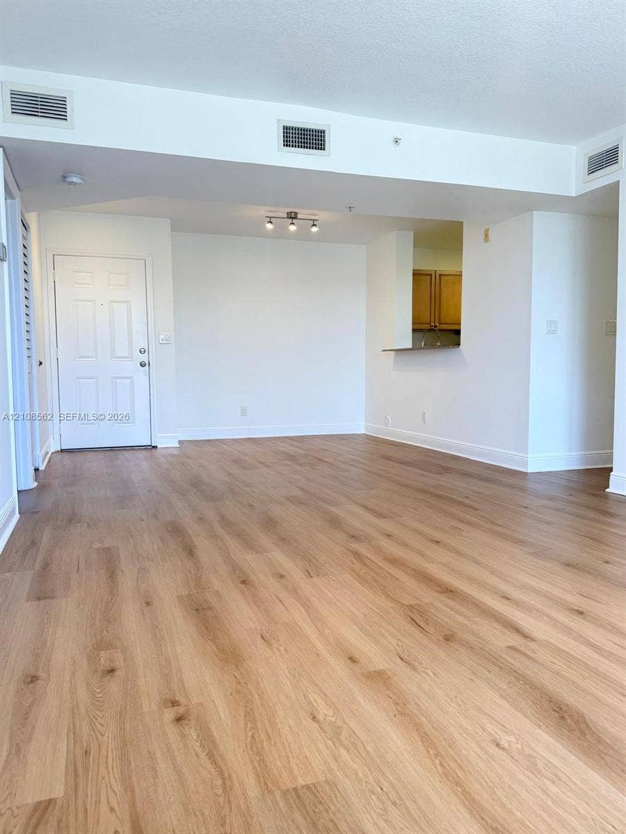 Wood-finish flooring, multi-panel entry door, and recessed track lighting