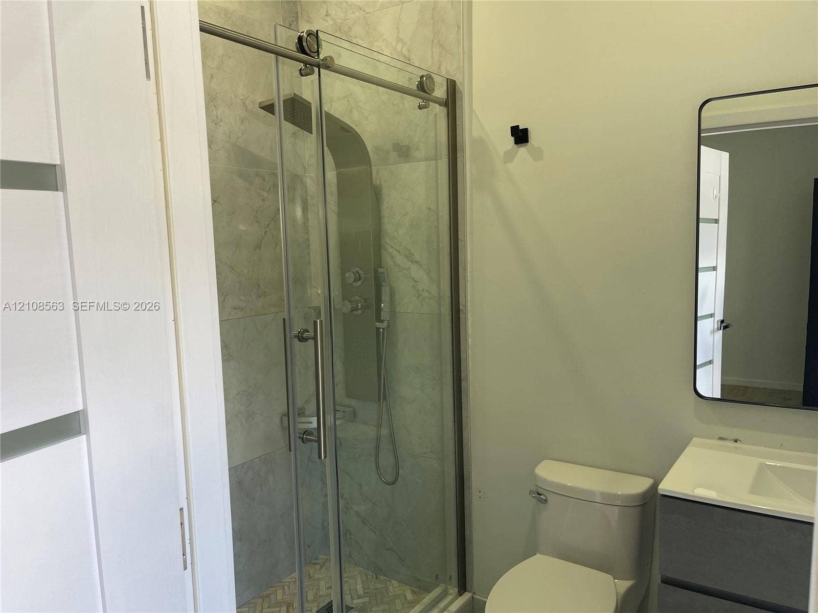 14554 SW 161 Court, #Studio, Miami, Miami, FL 33196 Shower enclosure featuring a stainless steel shower panel system, sliding glass doors, and tiled walls