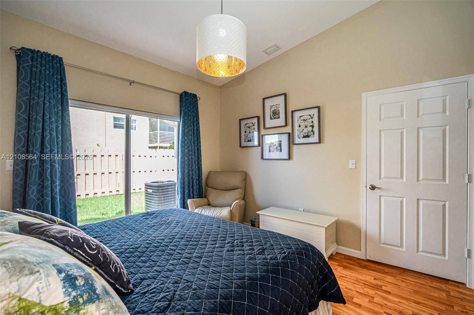 3111 NW 86th Avenue, Sunrise, FL 33351 Vaulted ceilings with a drum-style pendant light, wood-finish flooring, and sliding glass doors with exterior access