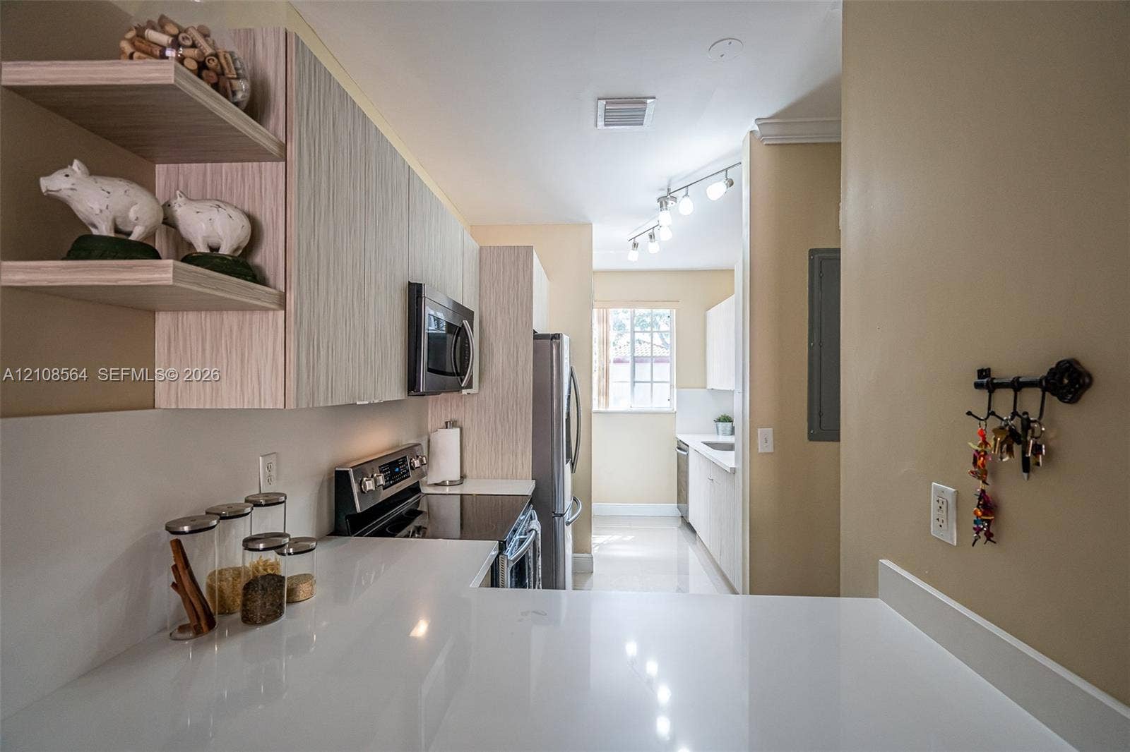 3111 NW 86th Avenue, Sunrise, FL 33351 Kitchen featuring light-toned wood-finish cabinetry, quartz countertops, stainless steel appliances, open shelving, and track lighting