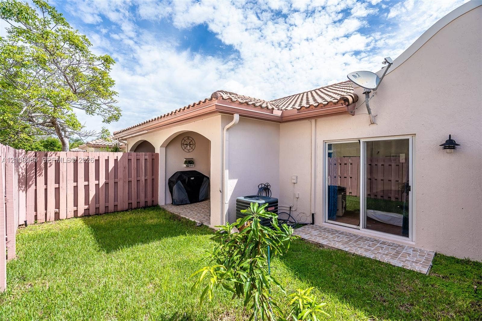3111 NW 86th Avenue, Sunrise, FL 33351 Private backyard featuring a covered patio, paved stone hardscaping, and privacy fencing
