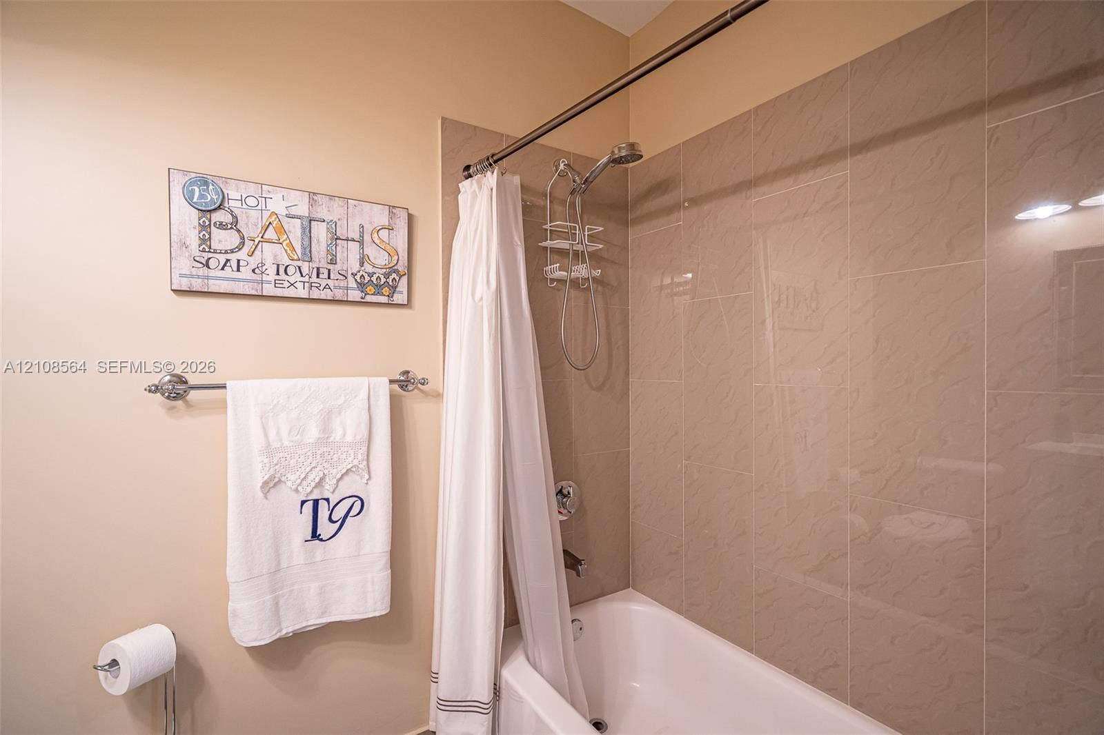3111 NW 86th Avenue, Sunrise, FL 33351 Bathtub with ceramic tile surround, integrated shower fixture, and polished metal towel bar
