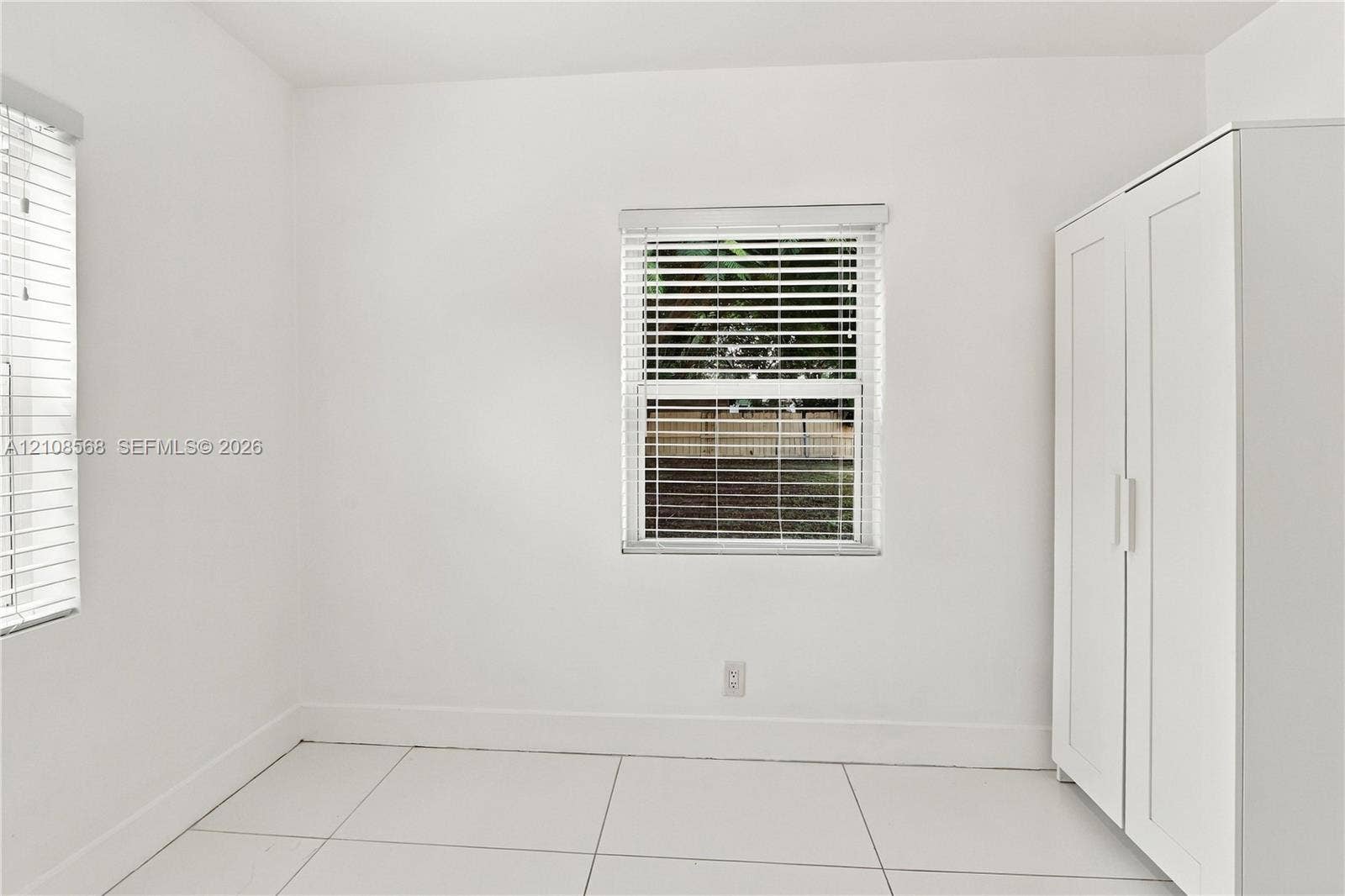 1229 NW 1st Avenue, Fort Lauderdale, Fort Lauderdale, FL 33311 Interior space featuring neutral wall tones, large-format tile flooring, and windows fitted with horizontal blinds