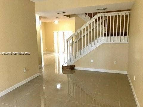 10841 SW 181st Lane, Miami, Miami, FL 33157 Large-format tile flooring, staircase featuring white wooden balusters and handrails, and recessed ceiling lighting