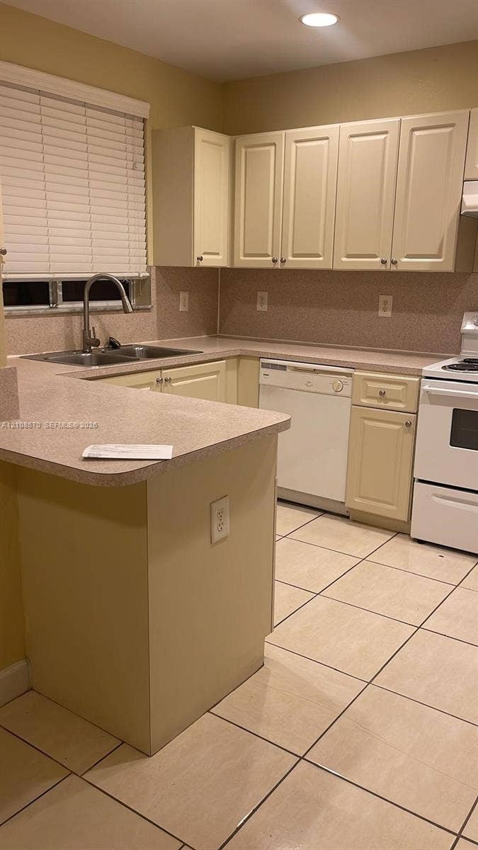 10841 SW 181st Lane, Miami, Miami, FL 33157 Kitchen featuring light-toned cabinetry, solid-surface countertops, tile flooring, a dual-basin stainless steel sink, and a built-in dishwasher