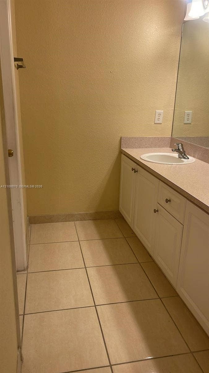 10841 SW 181st Lane, Miami, Miami, FL 33157 Bathroom vanity featuring white cabinetry, a solid-surface countertop, an integrated sink, and tile flooring