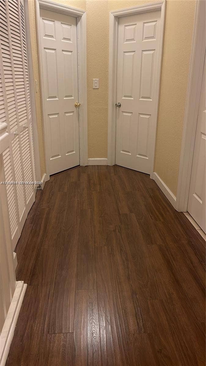 10841 SW 181st Lane, Miami, Miami, FL 33157 Wood-finish flooring, two six-panel interior doors, and white louvered closet doors