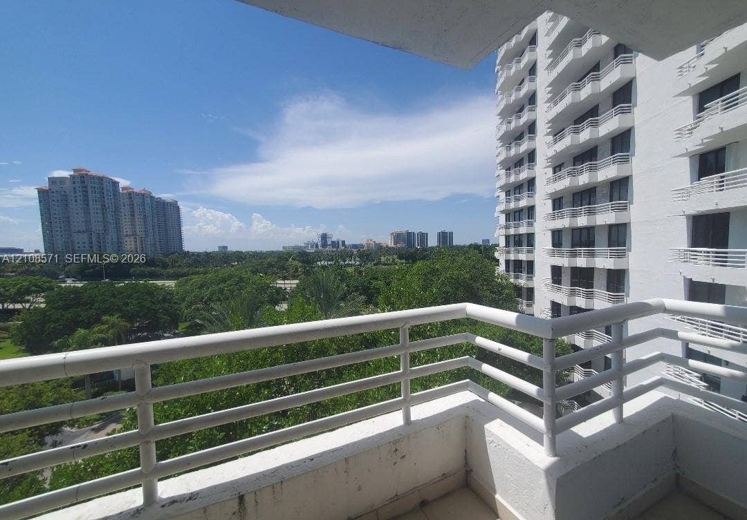 3300 NE 192nd Street, #602, Aventura, Aventura, FL 33180 Covered balcony featuring white railings, concrete flooring, and an expansive exterior landscape