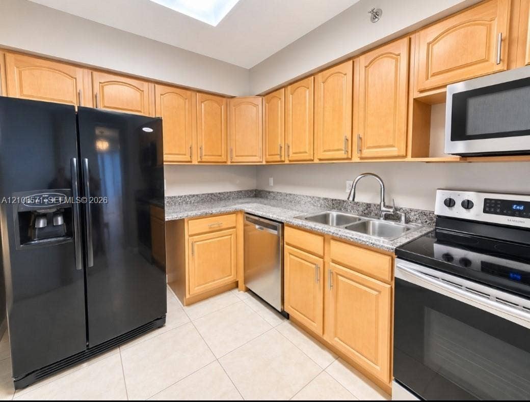 3300 NE 192nd Street, #602, Aventura, Aventura, FL 33180 Kitchen featuring light-finish cabinetry, stone-surface countertops, stainless steel appliances, a dual-basin sink, and tile flooring
