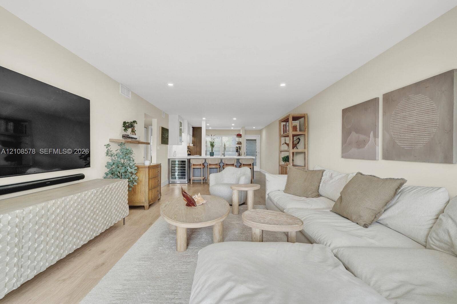 3005 Portofino Isle, #N2, Coconut Creek, Coconut Creek, FL 33066 Open-concept interior featuring light wood-finish flooring, recessed lighting, and a kitchen equipped with a built-in wine refrigerator and a breakfast bar