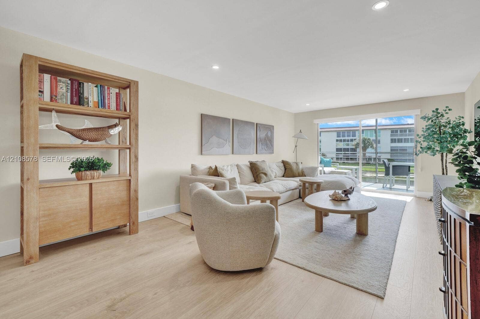 3005 Portofino Isle, #N2, Coconut Creek, Coconut Creek, FL 33066 Living area featuring light-toned wood-finish flooring, recessed lighting, and large sliding glass doors leading to an exterior screened balcony
