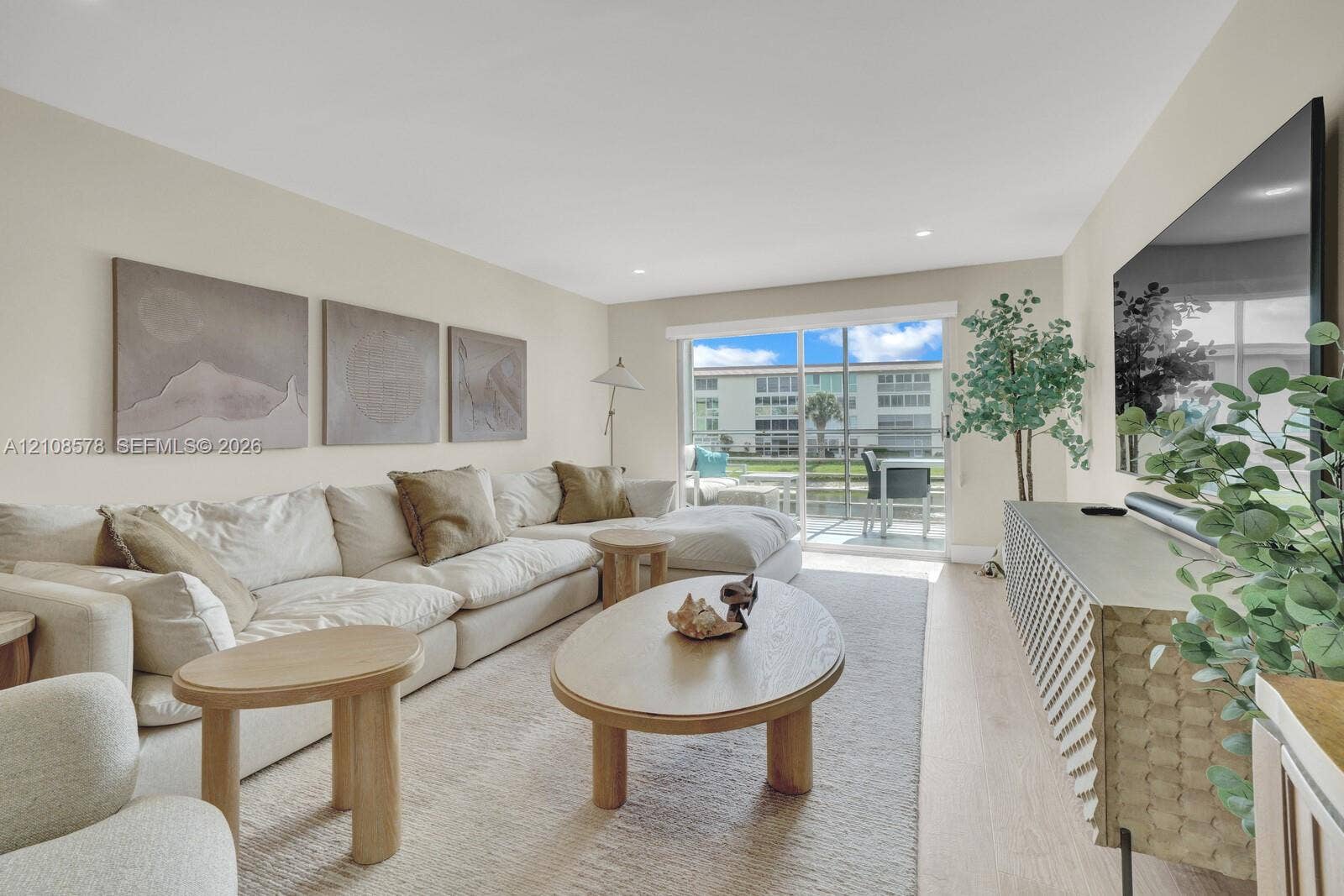 3005 Portofino Isle, #N2, Coconut Creek, Coconut Creek, FL 33066 Living area featuring wood-finish flooring, recessed lighting, and a large sliding glass door opening to a screened-in lanai