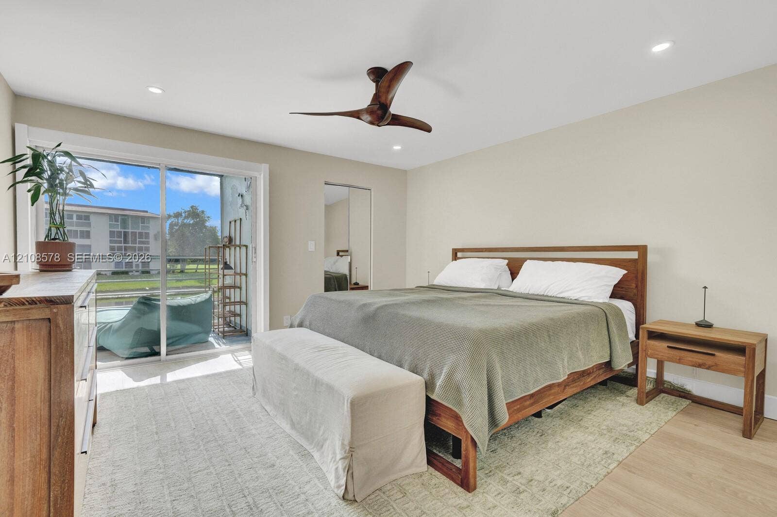 3005 Portofino Isle, #N2, Coconut Creek, Coconut Creek, FL 33066 Sliding glass door access to a private balcony, wood-finish flooring, recessed lighting, and a multi-blade ceiling fan