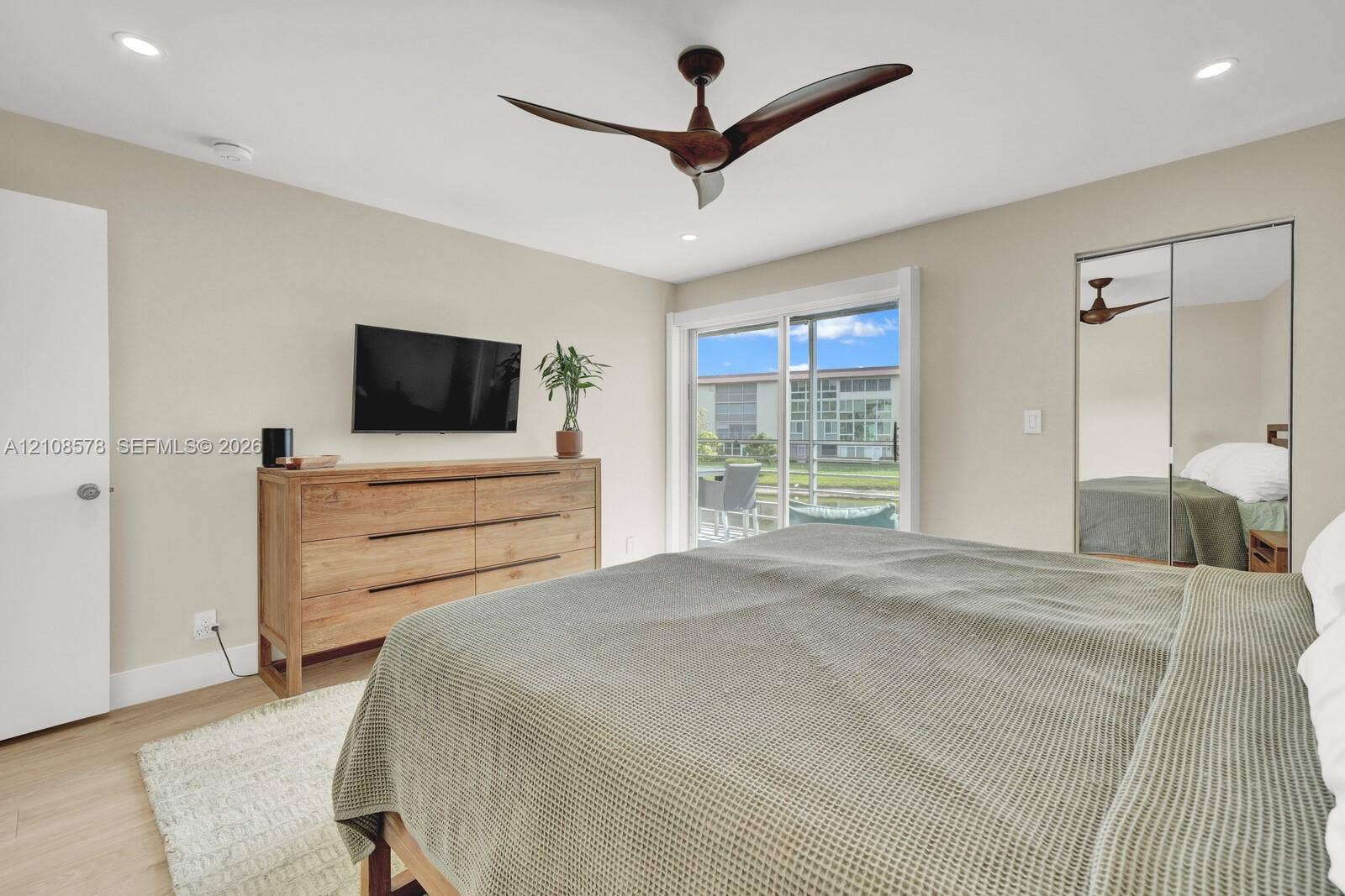 3005 Portofino Isle, #N2, Coconut Creek, Coconut Creek, FL 33066 Room featuring recessed lighting, a multi-blade ceiling fan, wood-finish flooring, sliding glass door access to the exterior, and a closet with mirrored sliding doors