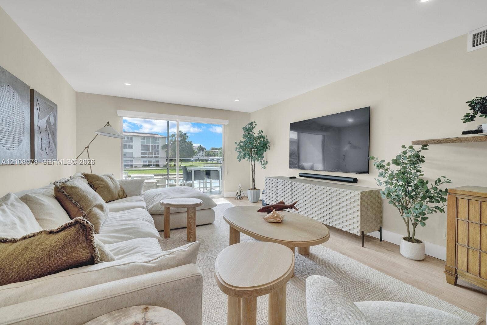 3005 Portofino Isle, #N2, Coconut Creek, Coconut Creek, FL 33066 Living area featuring light-toned wood-finish flooring, recessed lighting, and large sliding glass doors providing outdoor access