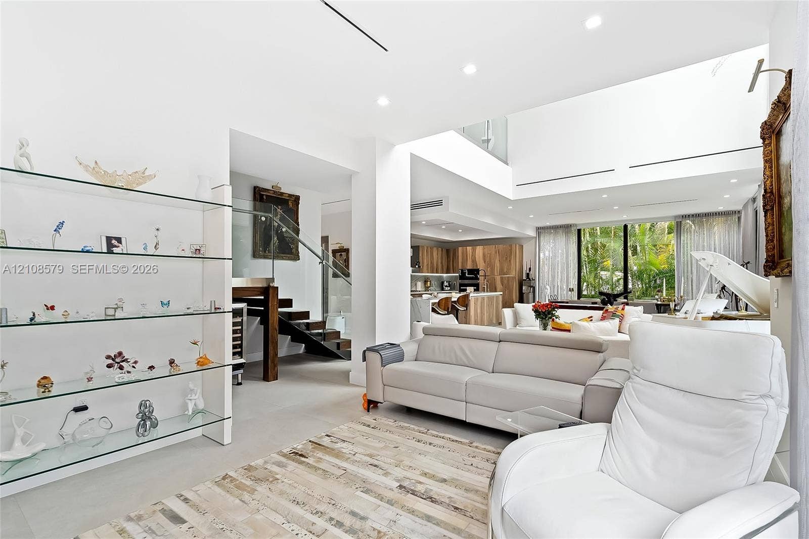 311 189th Street, #0, Sunny Isles Beach, Sunny Isles Beach, FL 33160 Open-concept floor plan featuring high ceilings, recessed lighting, built-in glass shelving, a glass-paneled staircase, and large-format tile flooring