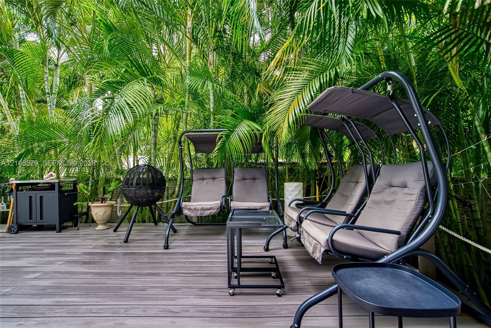 311 189th Street, #0, Sunny Isles Beach, Sunny Isles Beach, FL 33160 Outdoor deck featuring wood-finish composite planking and mature tropical foliage