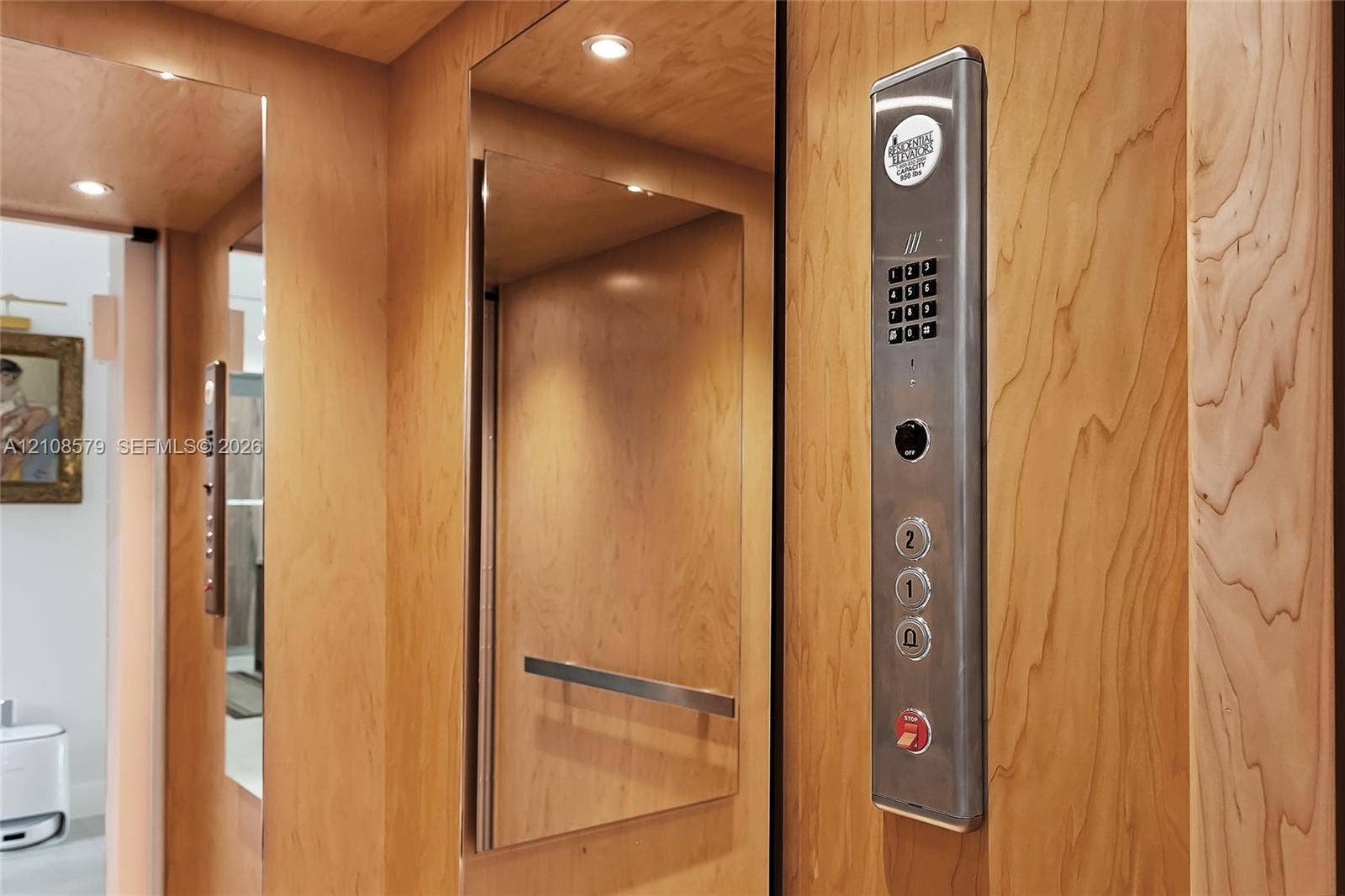 311 189th Street, #0, Sunny Isles Beach, Sunny Isles Beach, FL 33160 Elevator interior featuring wood-finish paneling, inset mirrored panels, recessed lighting, and a stainless steel control interface with numeric keypad