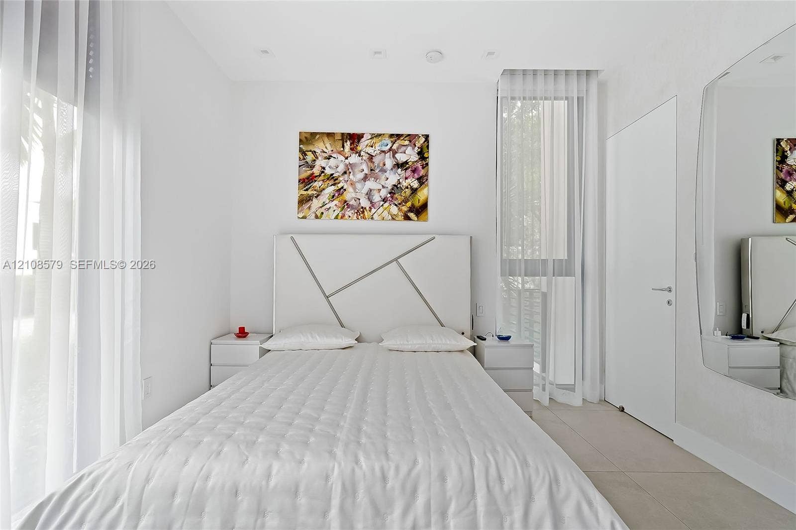 311 189th Street, #0, Sunny Isles Beach, Sunny Isles Beach, FL 33160 Floor-to-ceiling windows with sheer drapery, recessed ceiling lighting, large-format tile flooring, and a full-height wall-mounted mirror