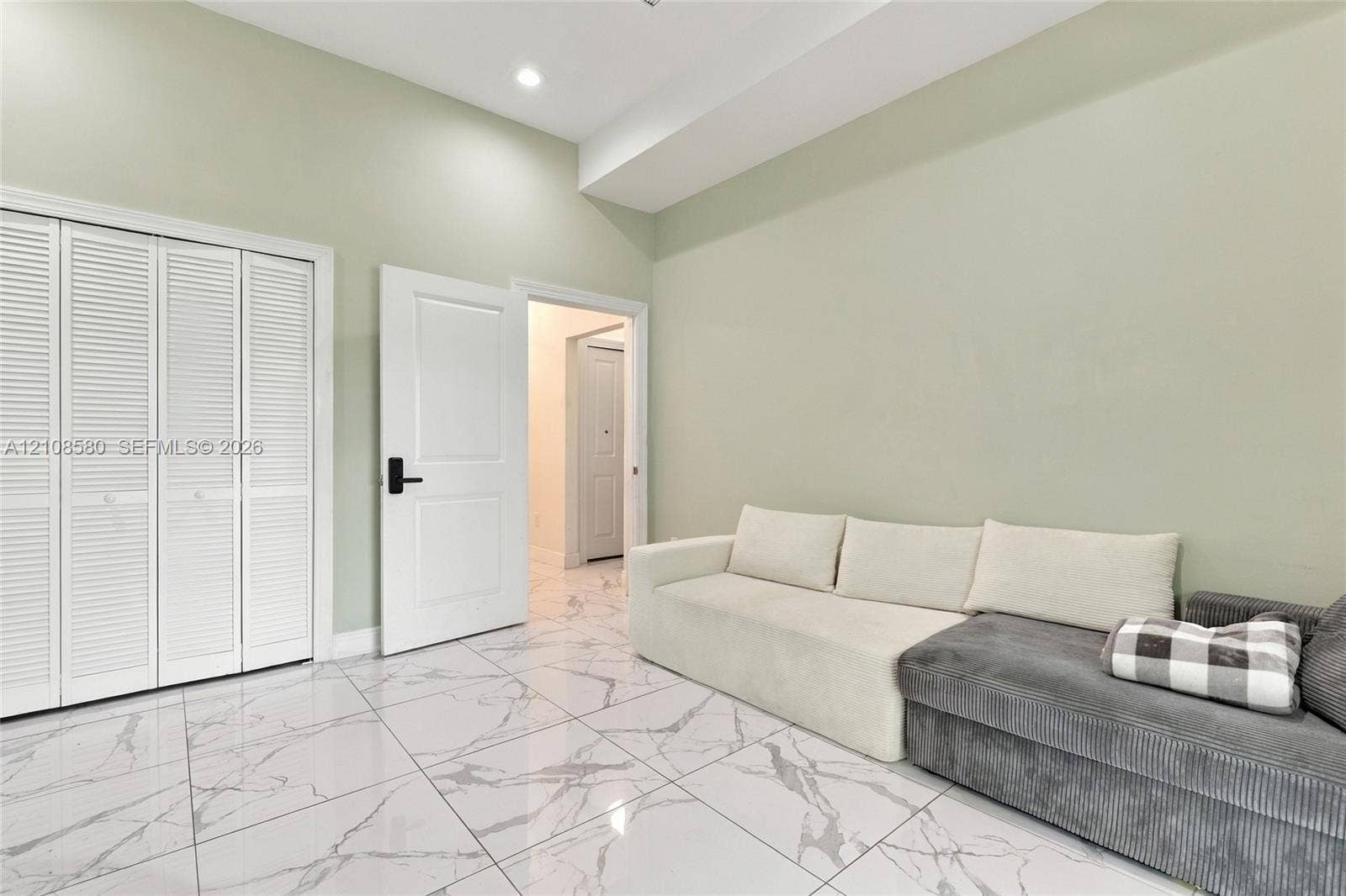 2363 NE 20 Th Avenue, Naples, FL 34120 Interior space featuring white stone-finish tile flooring, louvered closet doors, and a recessed ceiling light