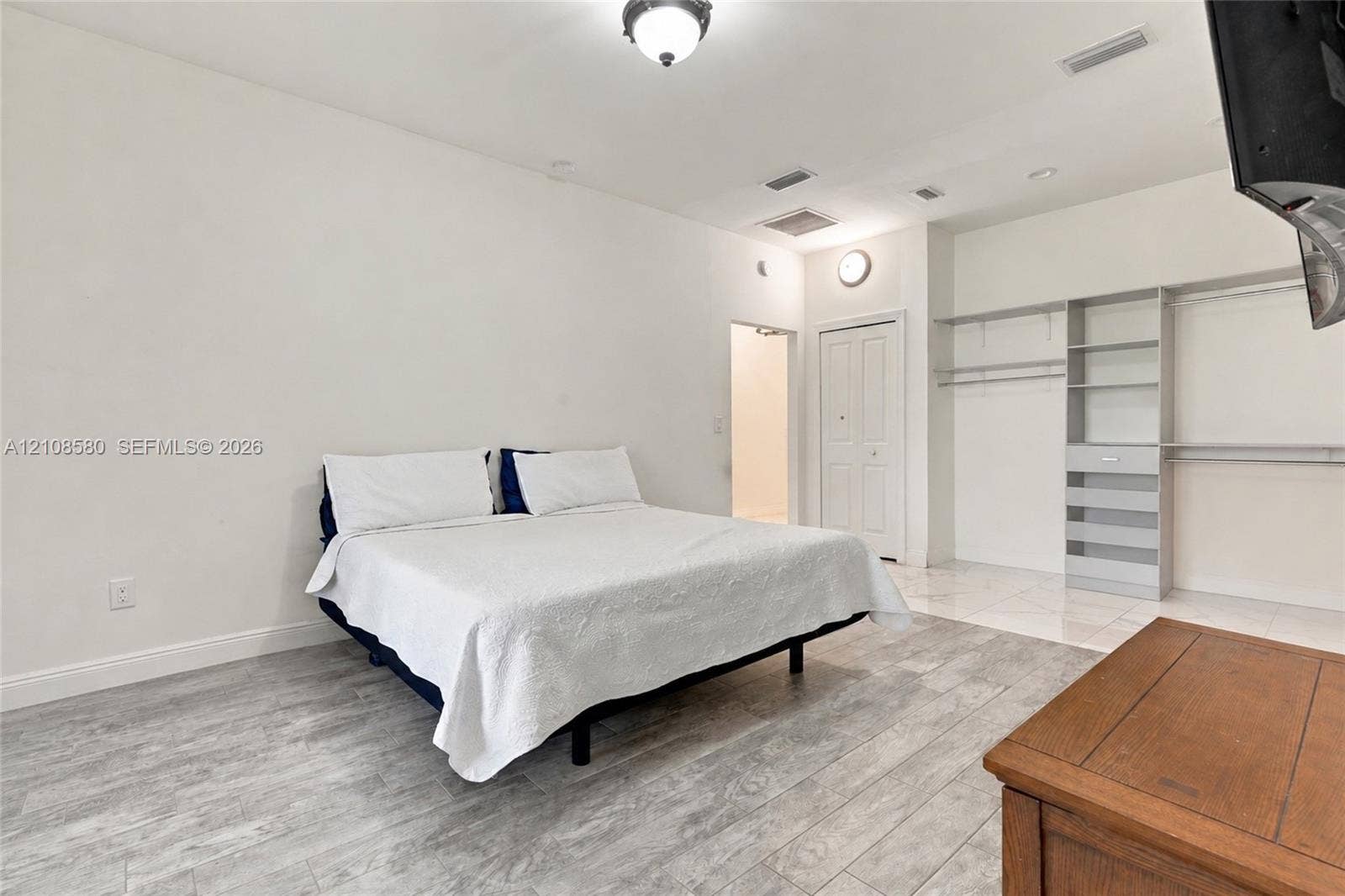 2363 NE 20 Th Avenue, Naples, FL 34120 Room featuring wood-finish tile flooring, recessed lighting, and built-in gray shelving with integrated hanging rods