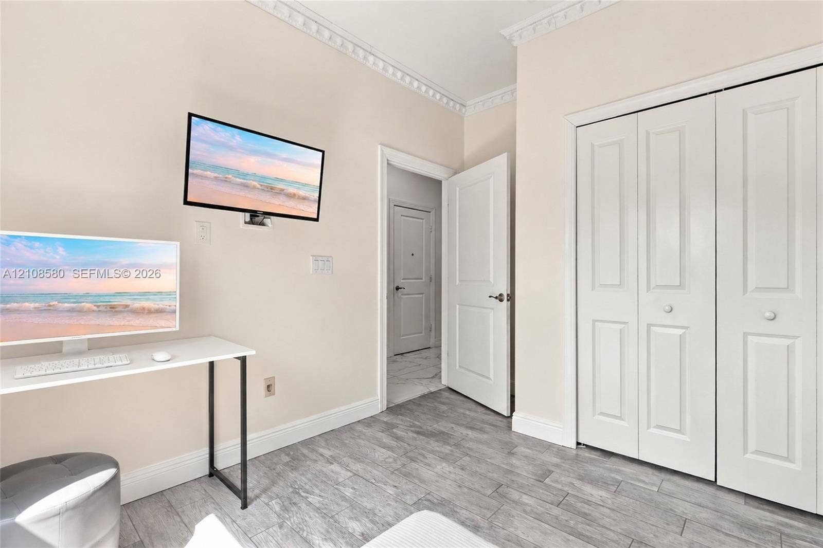2363 NE 20 Th Avenue, Naples, FL 34120 Wood-finish plank flooring, decorative crown molding, two-panel interior doors, and double-panel bifold closet doors
