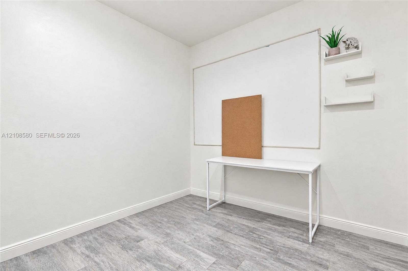 2363 NE 20 Th Avenue, Naples, FL 34120 Neutral interior space featuring wood-finish flooring and three wall-mounted floating shelves