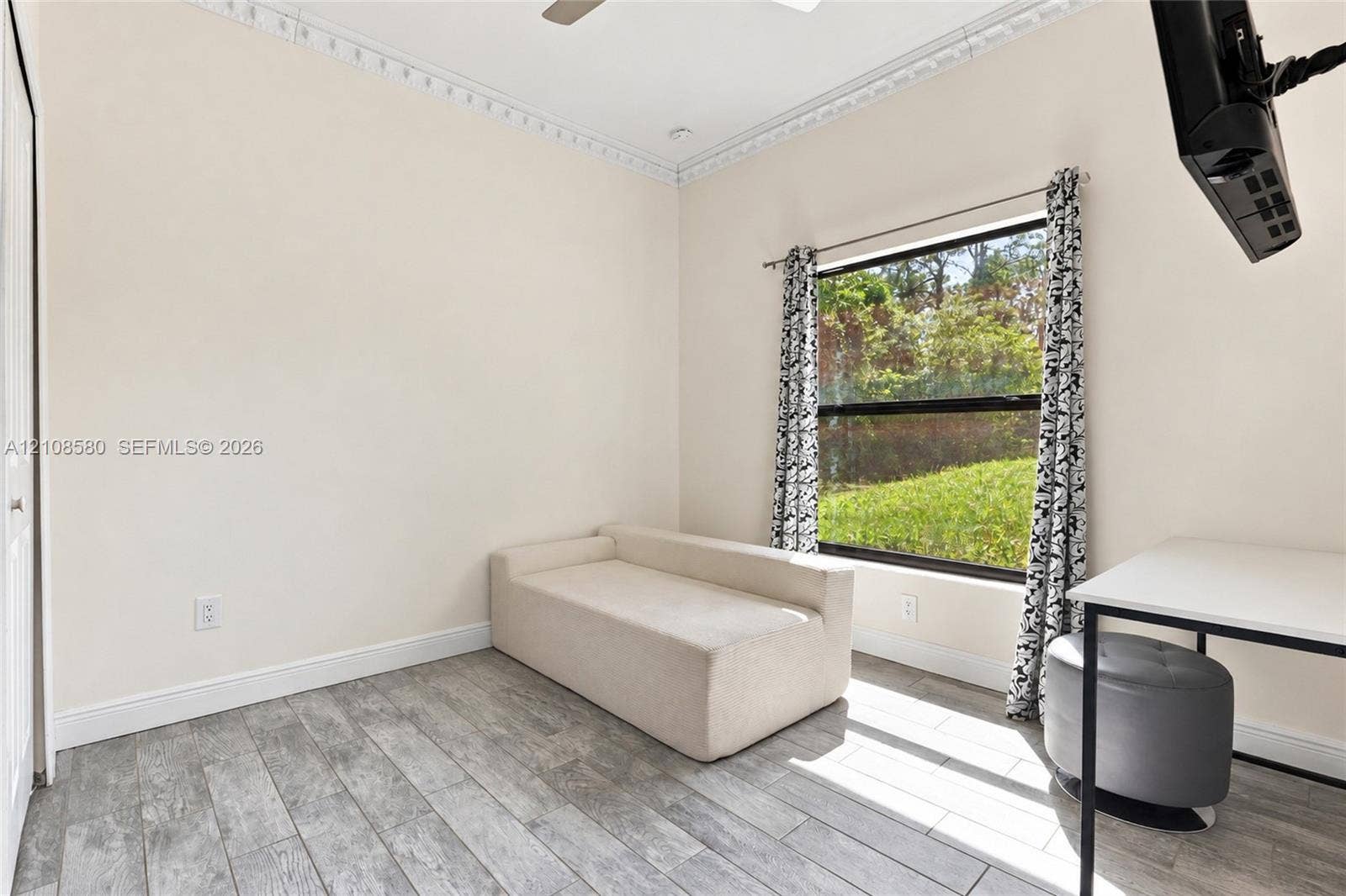 2363 NE 20 Th Avenue, Naples, FL 34120 Room featuring wood-finish tile flooring, decorative crown molding, and a large window