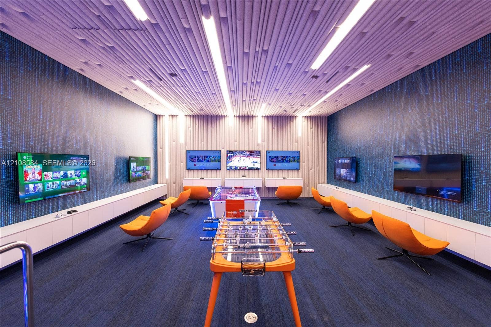 Custom-designed acoustic slat ceiling with integrated linear lighting, wall-to-wall textured accent wallpaper, wall-mounted display screens, and extensive built-in white cabinetry