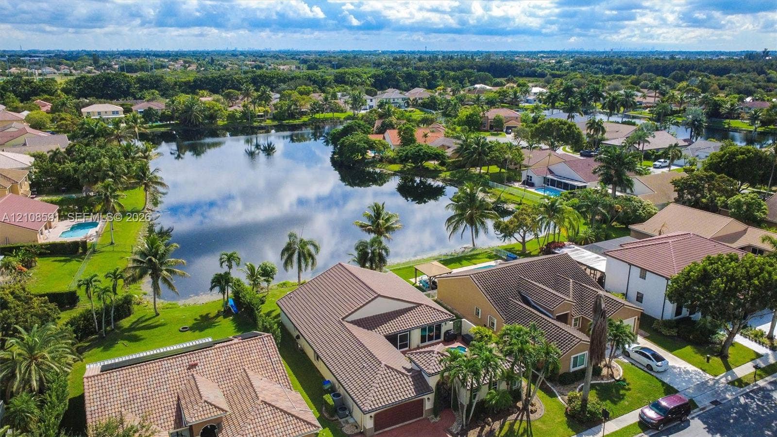 415 SW 200th Terrace, Pembroke Pines, FL 33029 Aerial perspective featuring a waterfront setting, tiled rooflines, manicured lawns, and mature landscaping