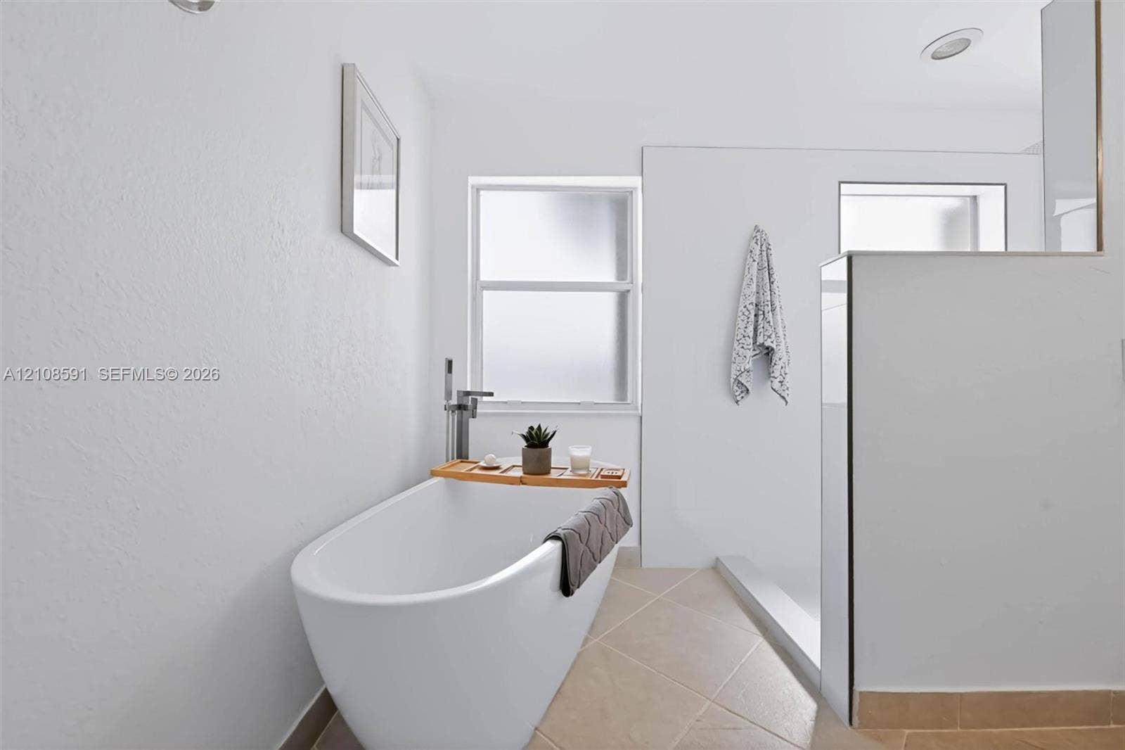 415 SW 200th Terrace, Pembroke Pines, FL 33029 Freestanding soaking tub with a floor-mounted faucet, walk-in shower enclosure, and neutral tile flooring